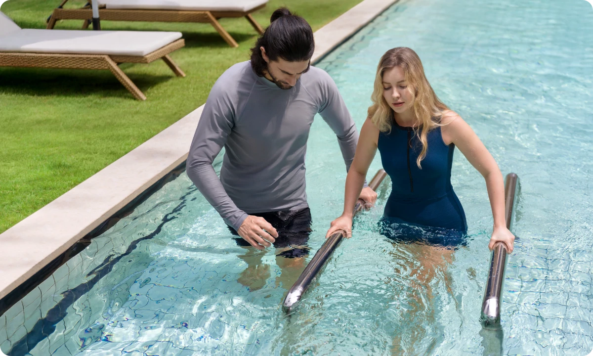 Des personnes nageant et marchant dans la piscine en utilisant les 12 modes de courant réglables du iGarden Swim Jet